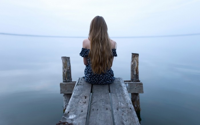 девушка сидит на озере